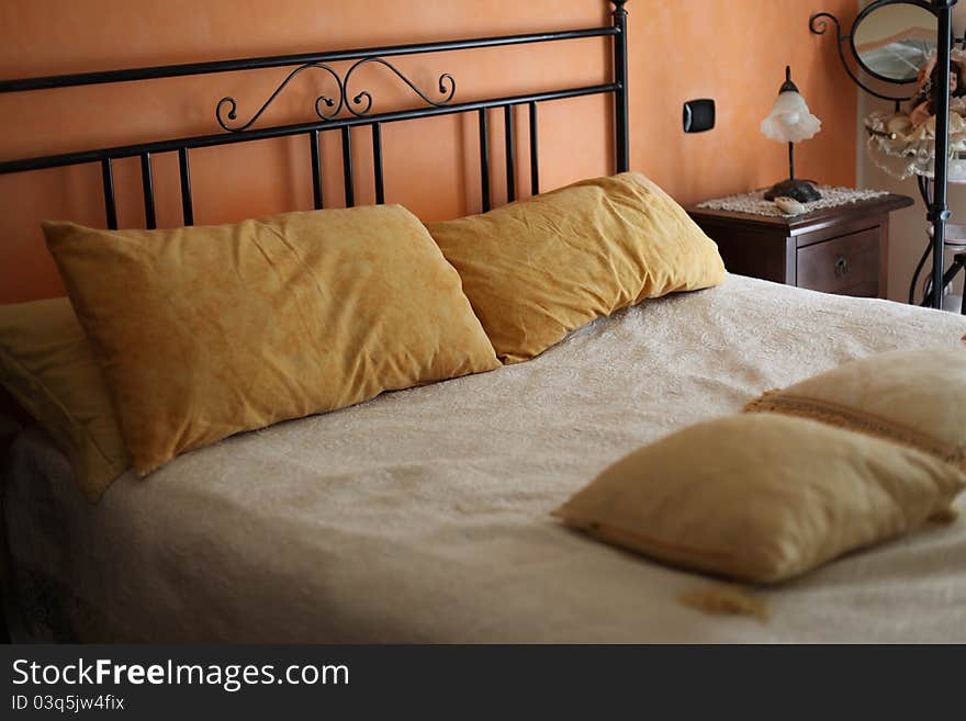 A comfortable rose bedroom with orange cushions