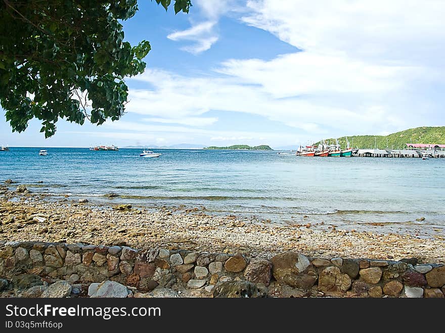 Sand beach on rocky coast line and the Fishing boa