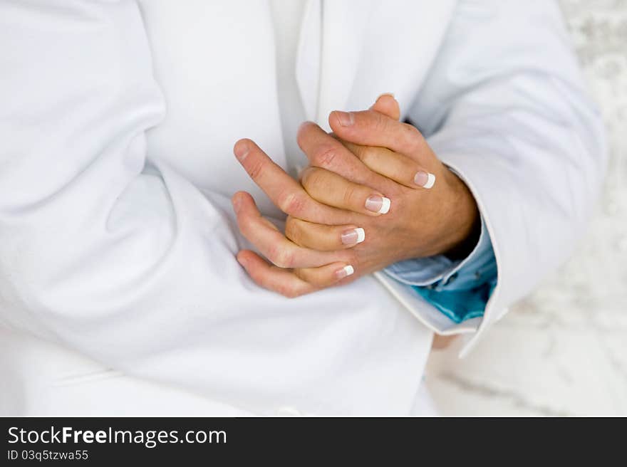 A horizontal photo of a caucasian bride and groom holding hands during a wedding reception