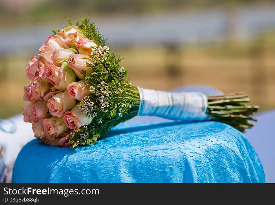 A wedding bouquet of roses lying on a table outdoors