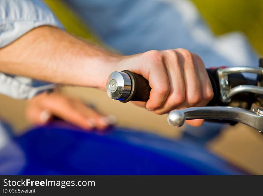 A close up of a man holding a motorbike handle. A close up of a man holding a motorbike handle