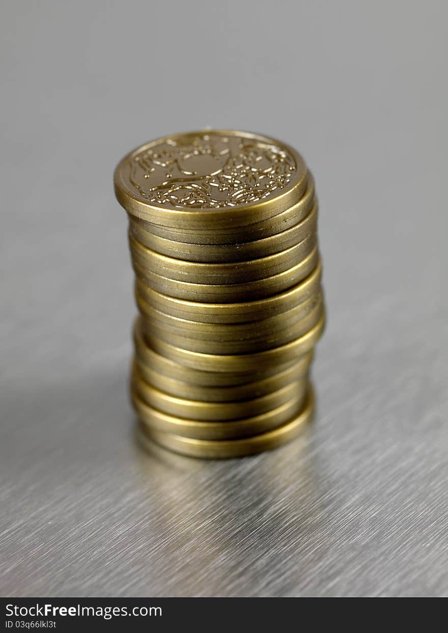 Australian dollar coins stacked and against a silver background