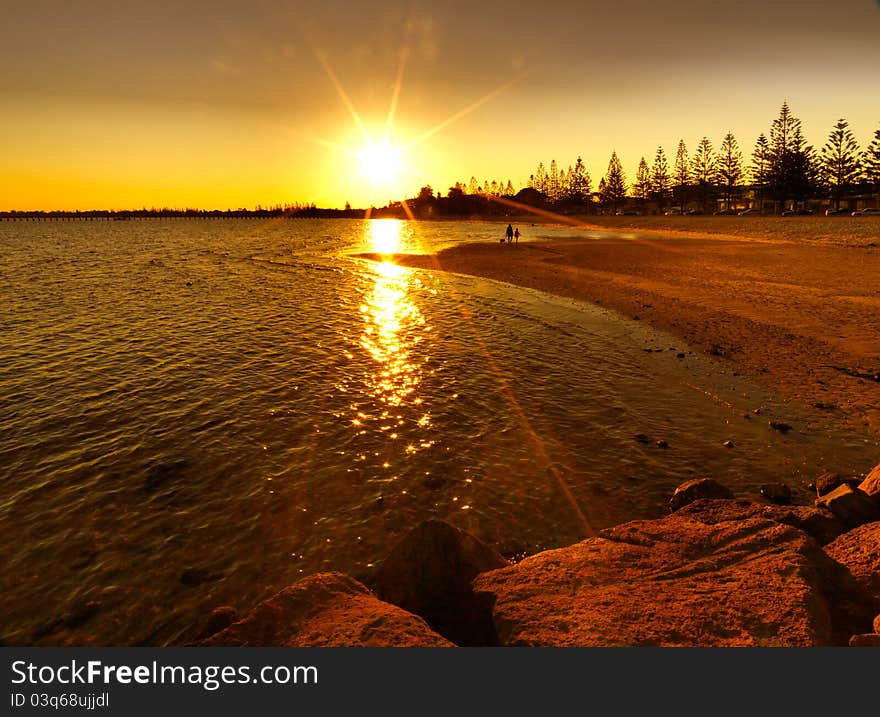 Bright red sunset over water on beach