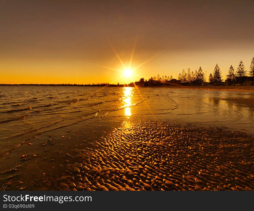 Bright red sunset over water on beach