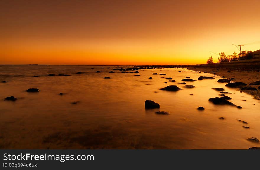 Bright red sunset over water on beach