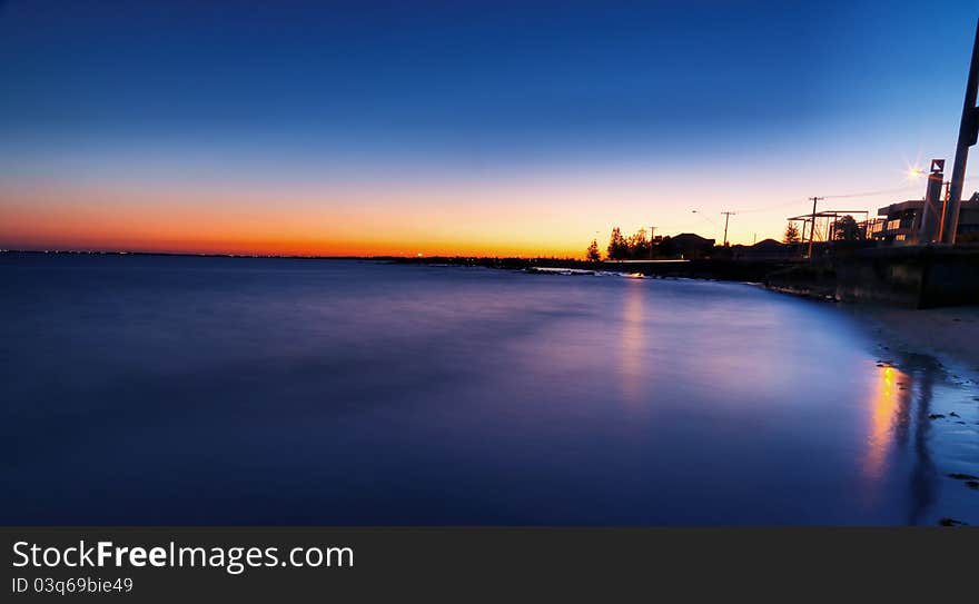 Bright blue sunset over water on beach with