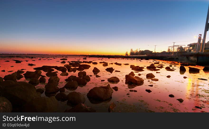 Bright red sunset over water on beach