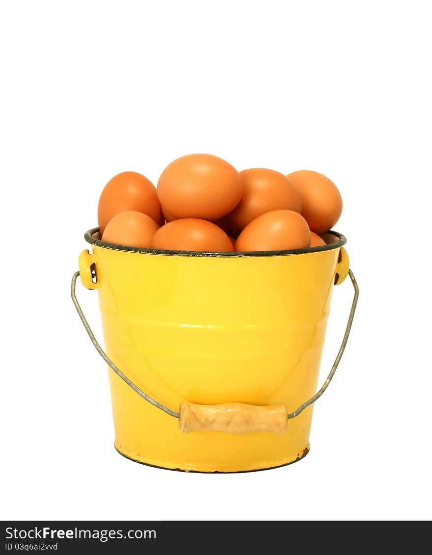 Eggs in yellow old metal bucket isolated on white background