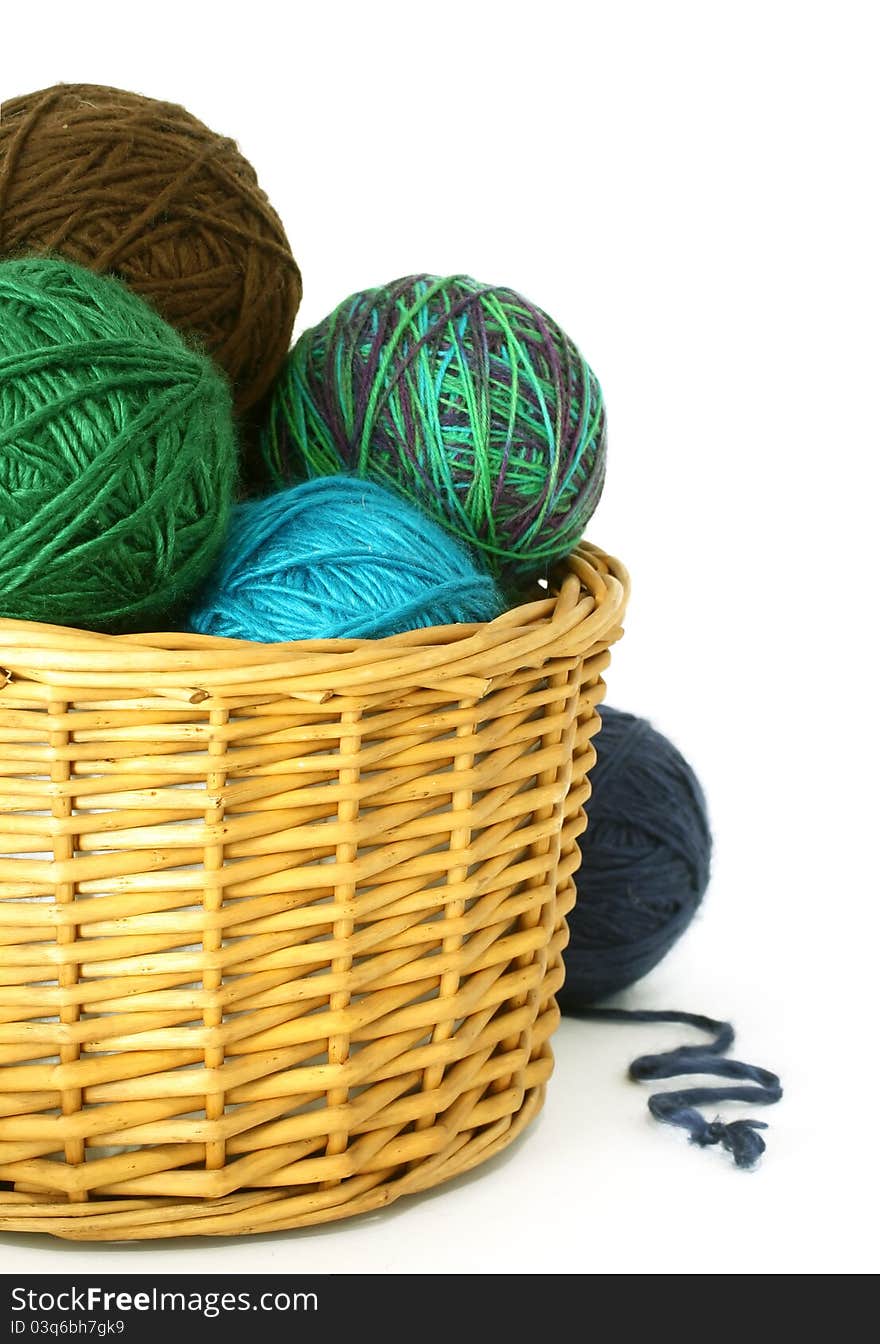 Wool balls in a wattled basket on white background. Wool balls in a wattled basket on white background