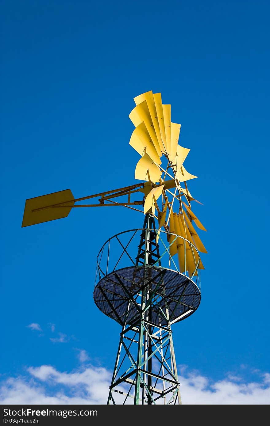 Yellow windmill and blue sky with clouds behind it. Yellow windmill and blue sky with clouds behind it