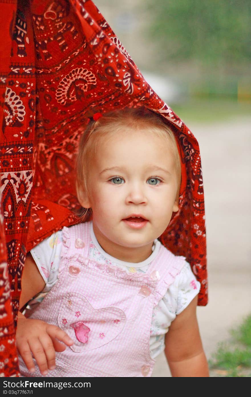 Portrait of the little girl hiding in oriental silks. Portrait of the little girl hiding in oriental silks