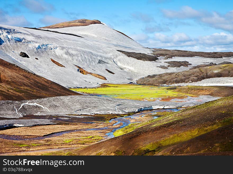 Majestic Mountain landscape in green wally with crystal river. Iceland