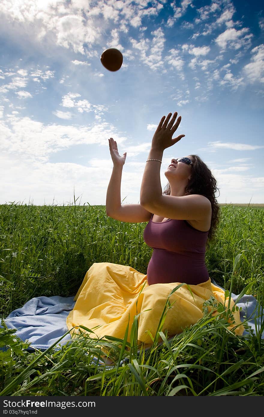 Pregnant woman on green grass field under blue sky