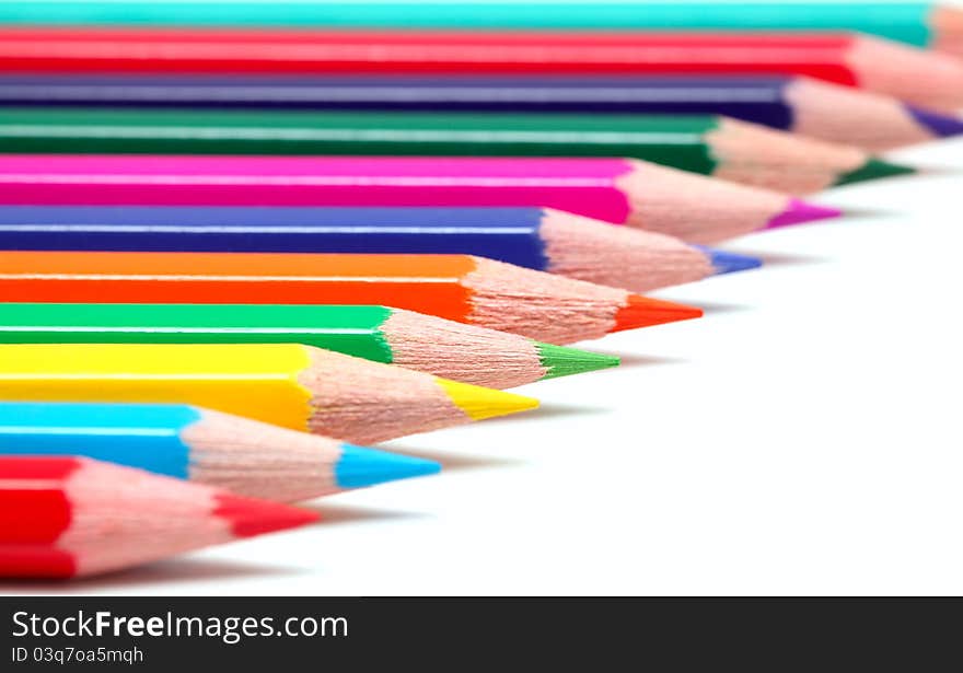 Colorful pencils on white surface (isolated with shadows)