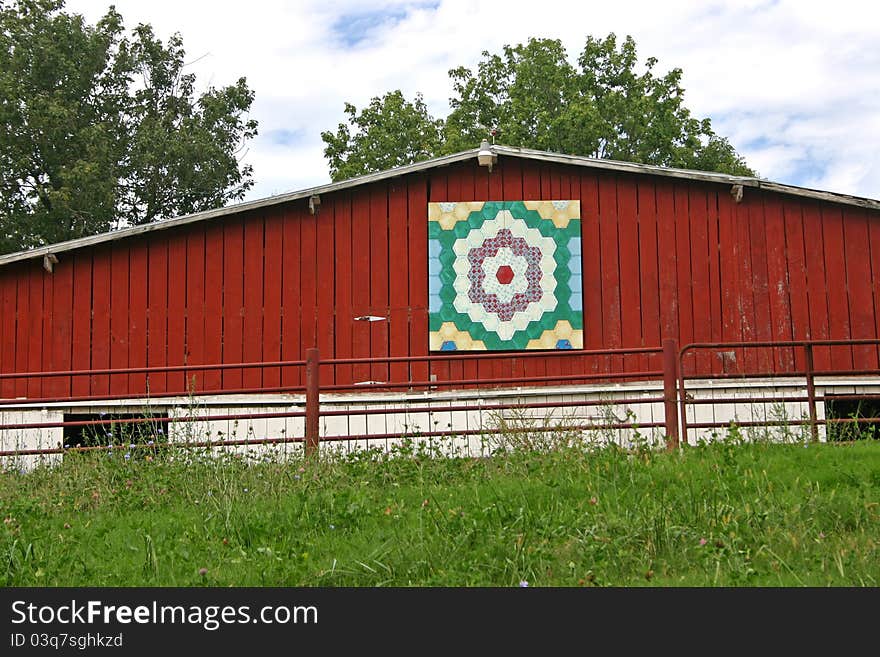 A barn with a quilt square over the door. A barn with a quilt square over the door