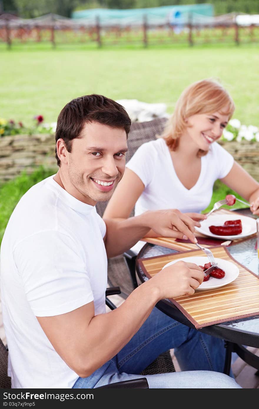 The smiling young couple eating. The smiling young couple eating