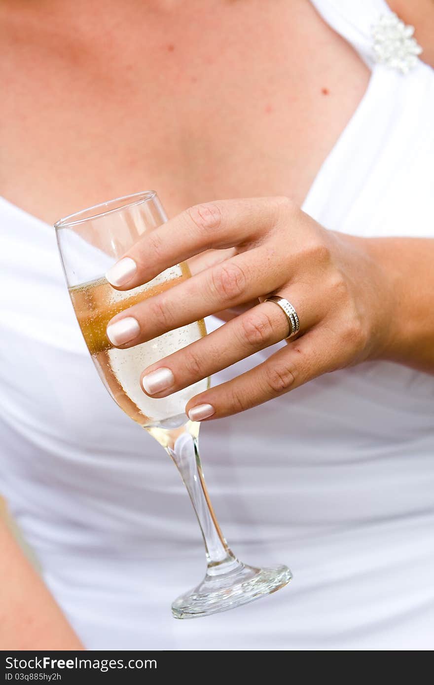 A caucasion bride holding a full glass of champange just after getting married. A caucasion bride holding a full glass of champange just after getting married.