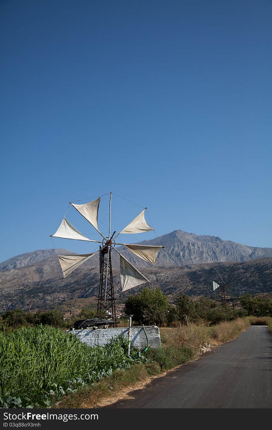 Wind turbine to power a water pump next to a pool of water