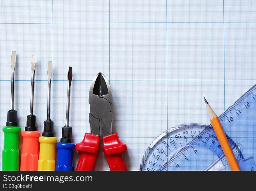 Various work tools near rulers on grarh paper background