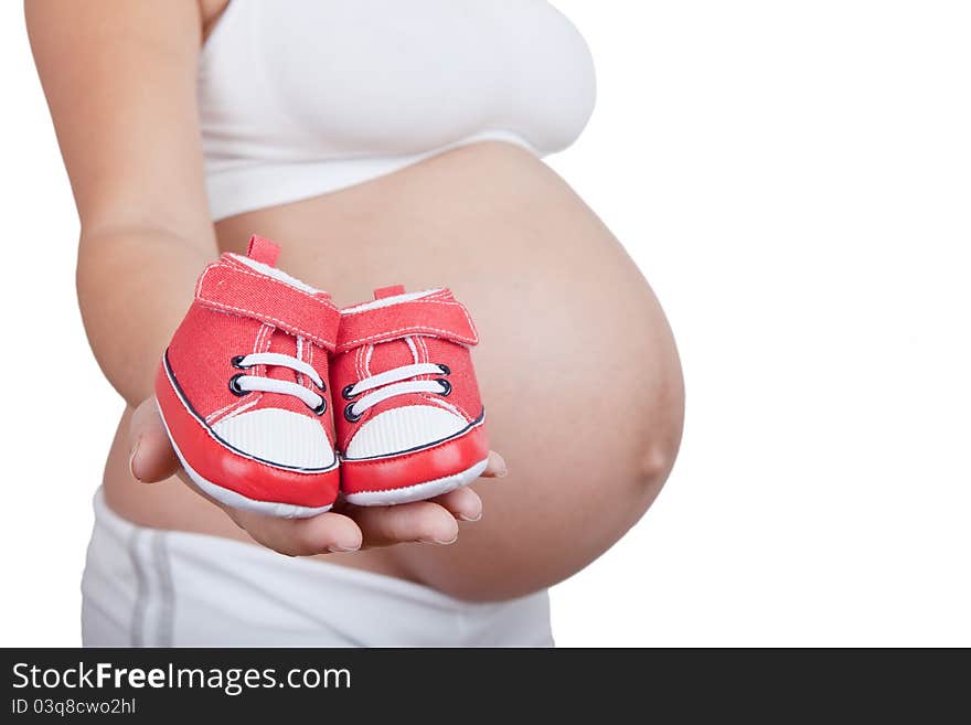 Pregnant woman hold in hand red baby boots