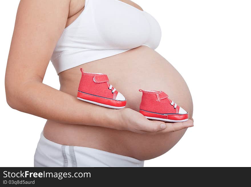 Pregnant woman hold in hand red baby boots isolated