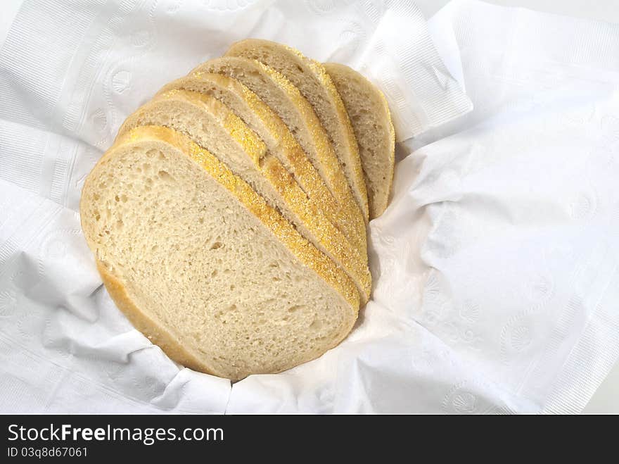 Fresh half loaf of sour dough bread is spread out in paper napkin. Fresh half loaf of sour dough bread is spread out in paper napkin.