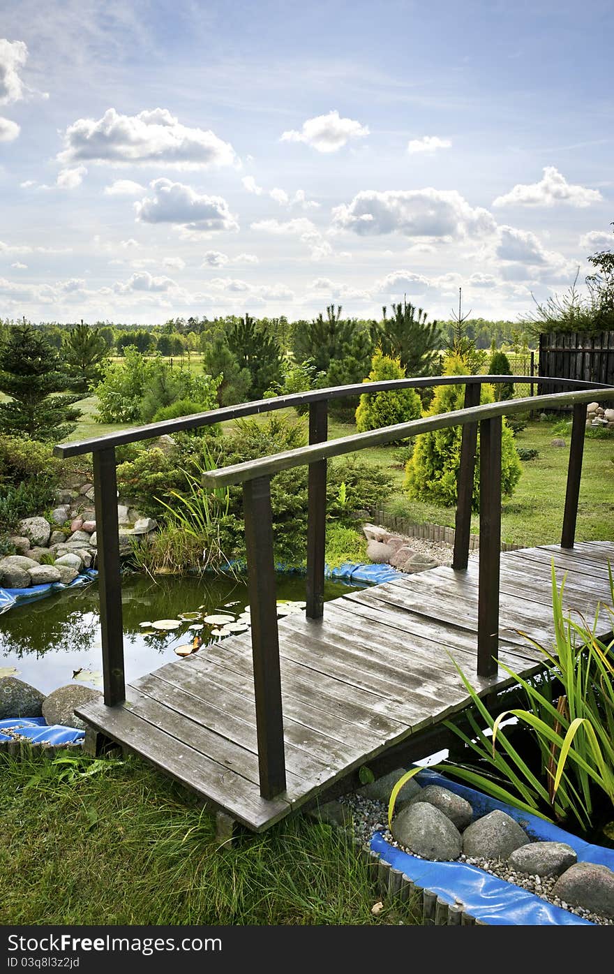 Wooden bridge over small lake on countryside