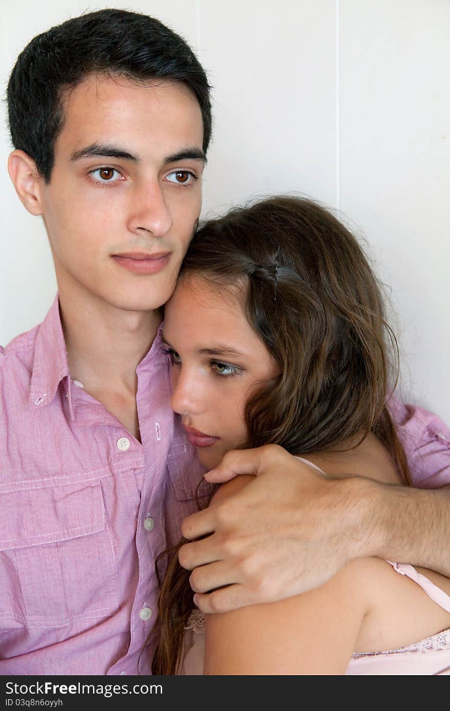 A simple portrait of a cute young couple cuddling, with the men's arm around the women's shoulder. A simple portrait of a cute young couple cuddling, with the men's arm around the women's shoulder.