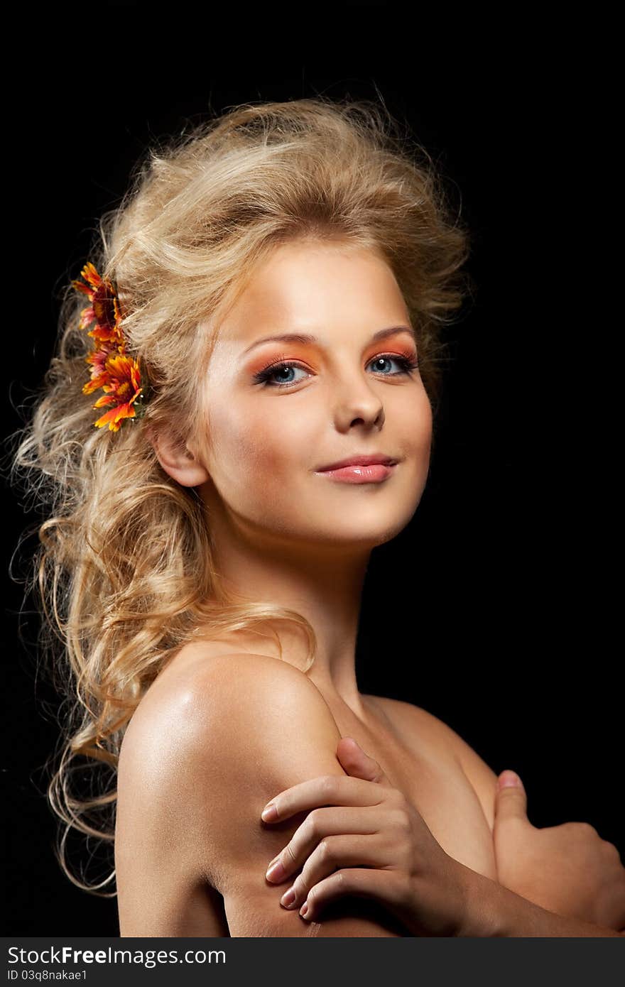 Beautiful blond woman with flower garland in dark