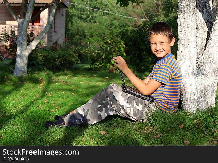 Boy on laptop outdoor