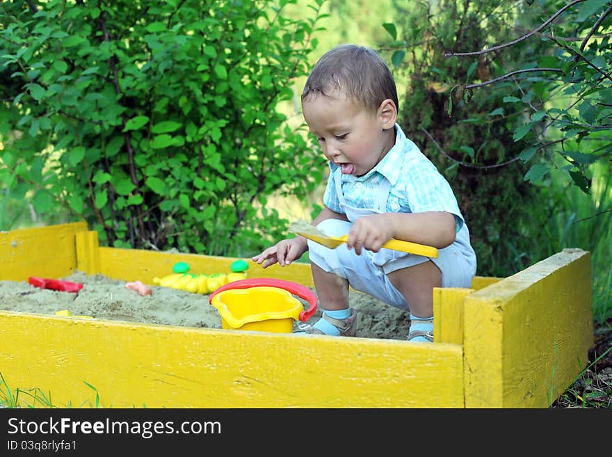 Baby plays with toys in sandbox. Baby plays with toys in sandbox