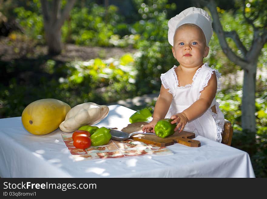 Sweet little baby is ready to cook vegetables. Sweet little baby is ready to cook vegetables.