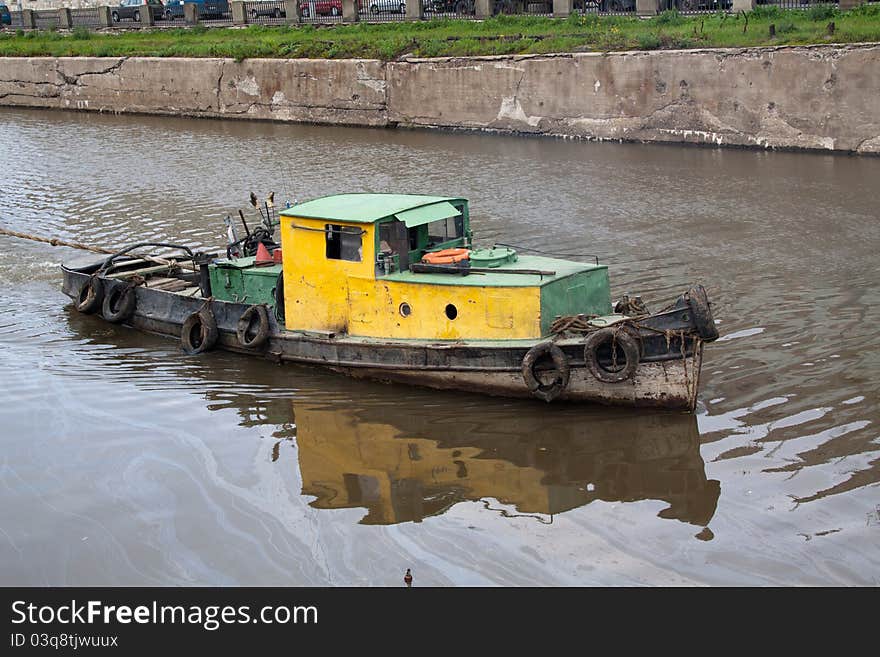 Yellow old tugboat on water