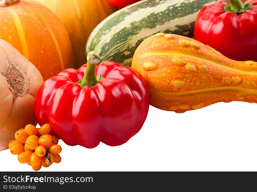 Autumn still-life filled with vitamins from red paprika, pumpkin, vegetable marrows and ripe sea-buckthorn berries on isolated white background. Autumn still-life filled with vitamins from red paprika, pumpkin, vegetable marrows and ripe sea-buckthorn berries on isolated white background