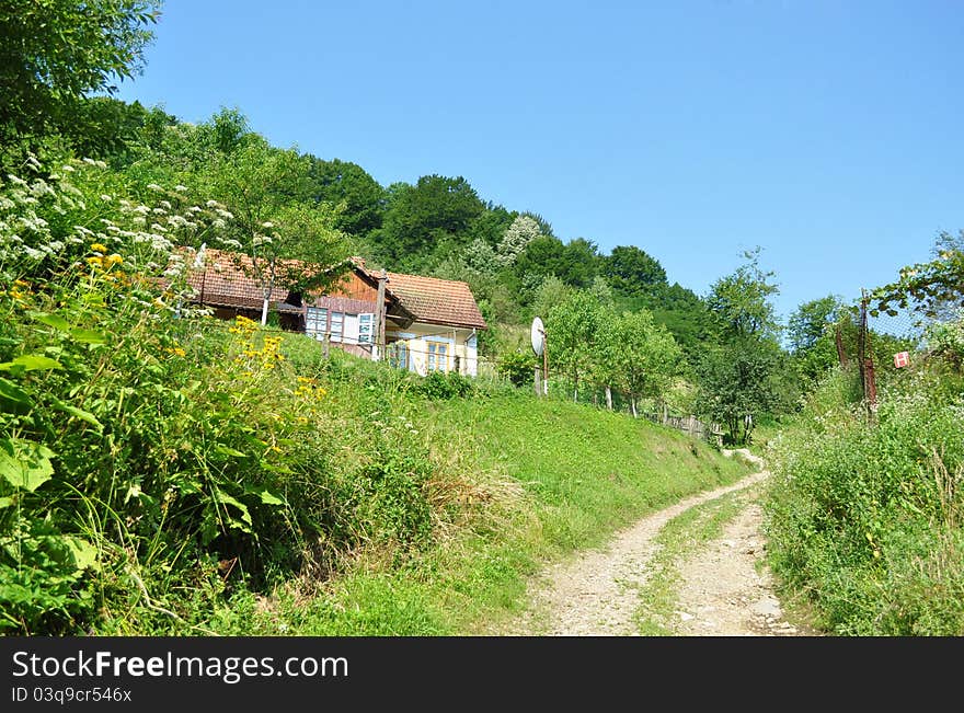 Path leading to nowhere and a house at the mountain.