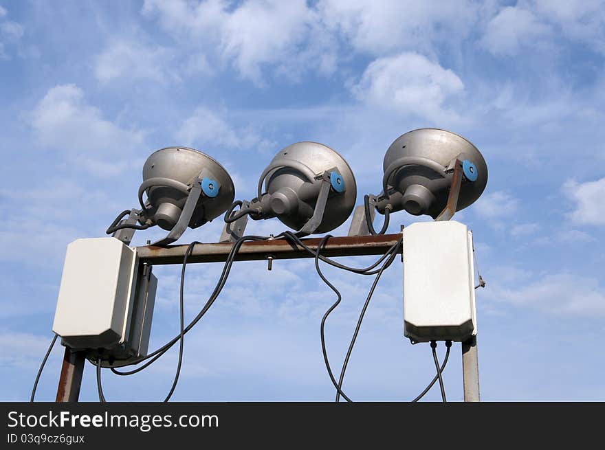 The set of three illumination lamps on blue sky with white clouds