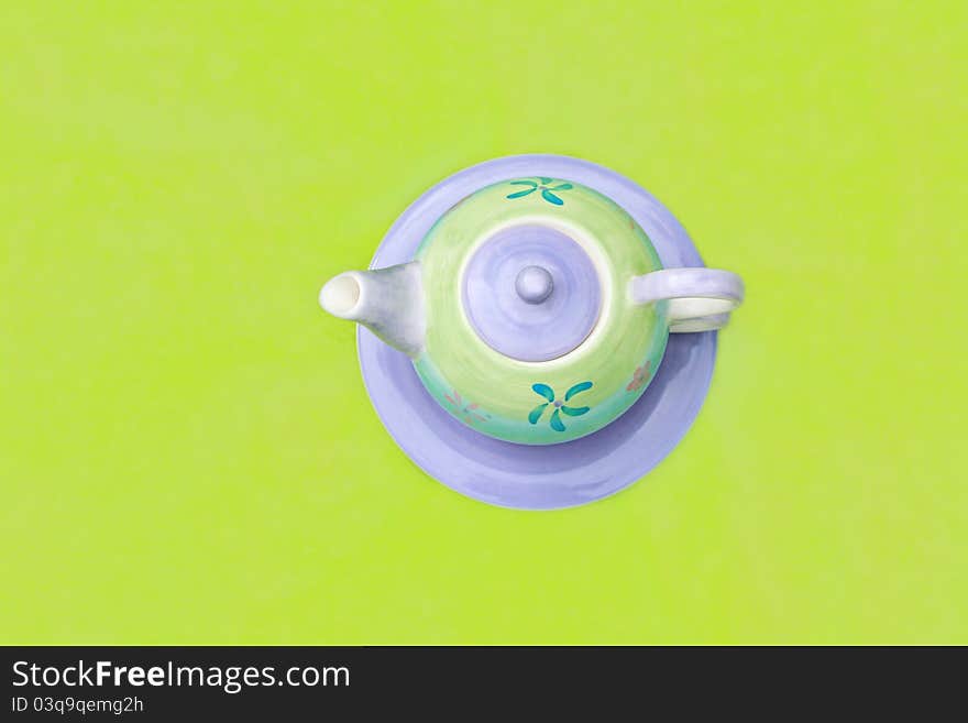 Lovely pastel teapot on green background