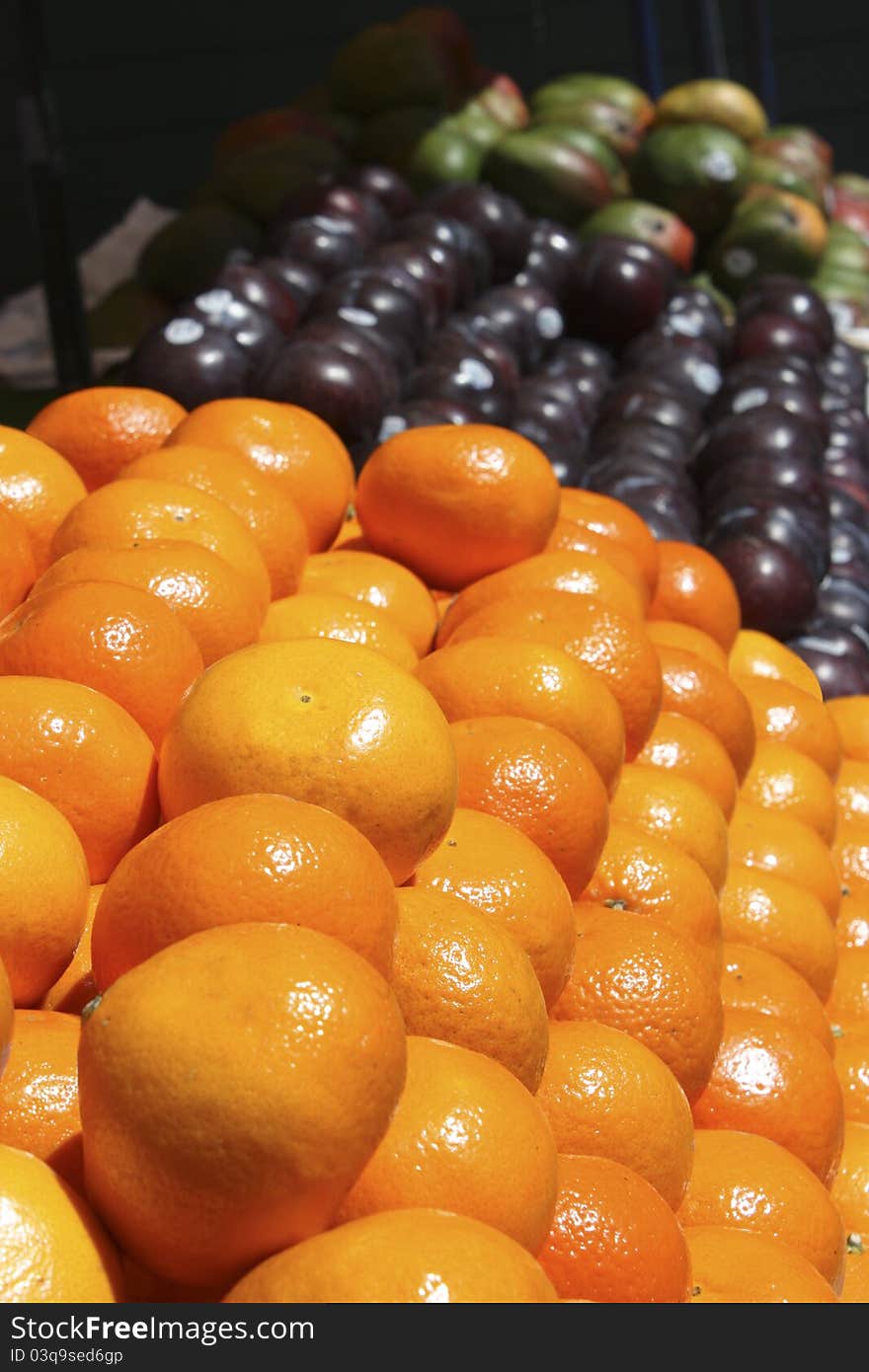 Rack of oranges and plums at a farmer's market