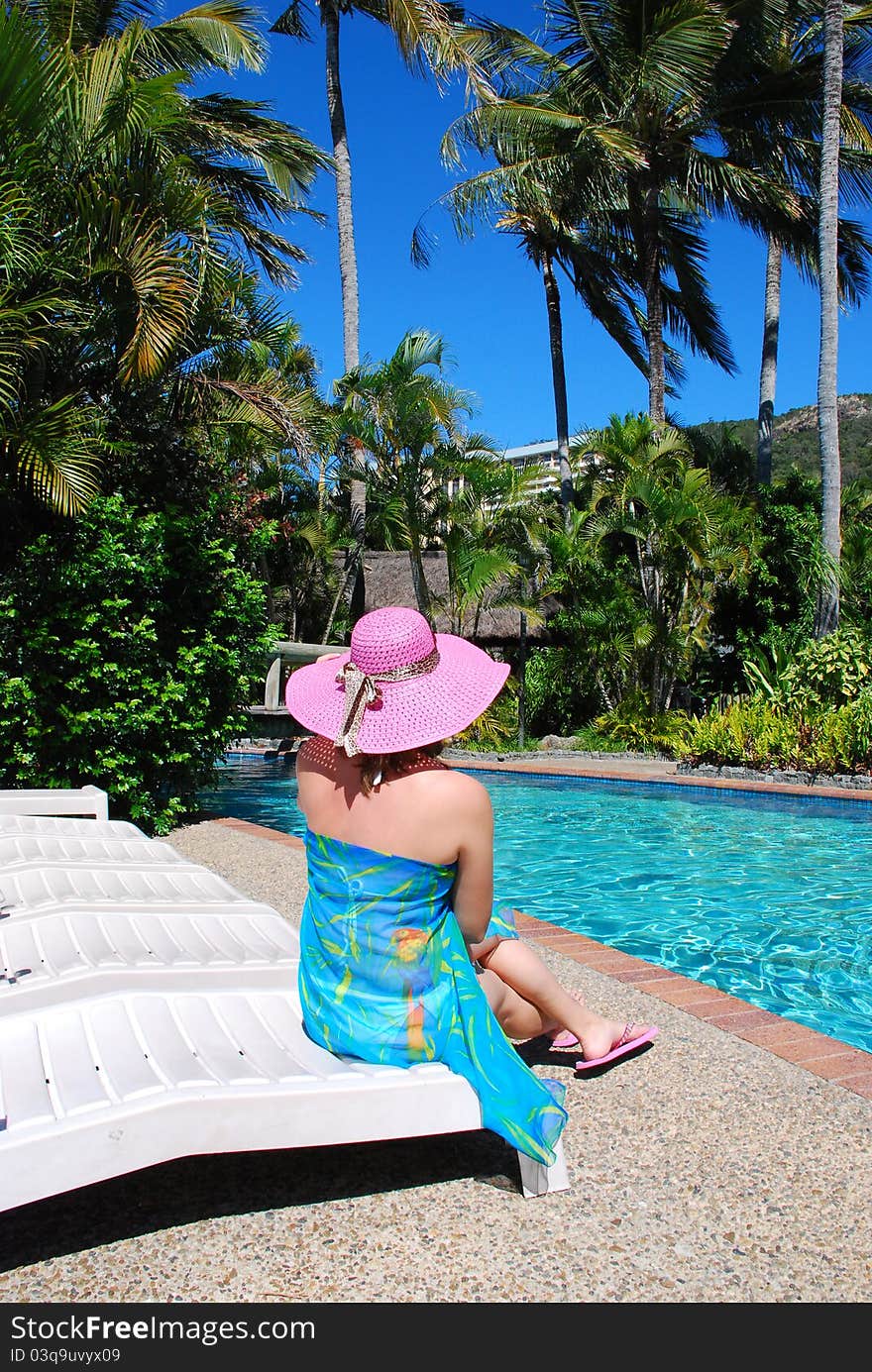 Young woman siting nearly a swimming pool