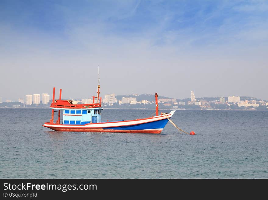 Fishing boat in wide ocean near city