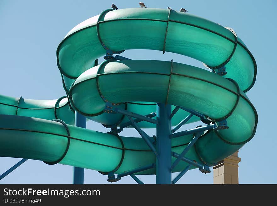 This is a view of the coiled tubes of a green water slide at a tourist amusement park