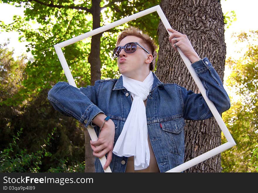 Young human on the green grass with white frame, he has blue goggles and jean jacket and white scarf he is funny. Young human on the green grass with white frame, he has blue goggles and jean jacket and white scarf he is funny