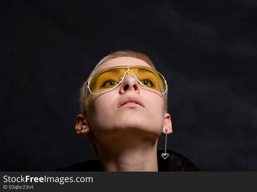 The young girl in a leather jacket and yellow glasses