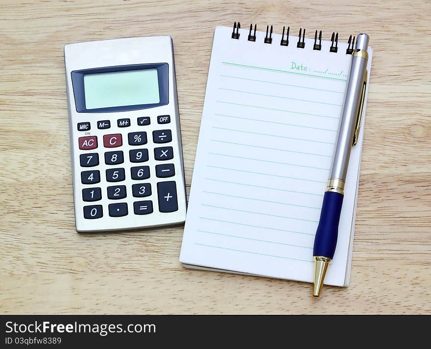 Notebook, silver ballpen and calculator