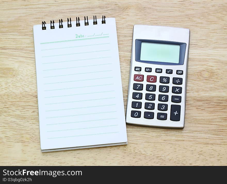 Calculator And Notebook On Table