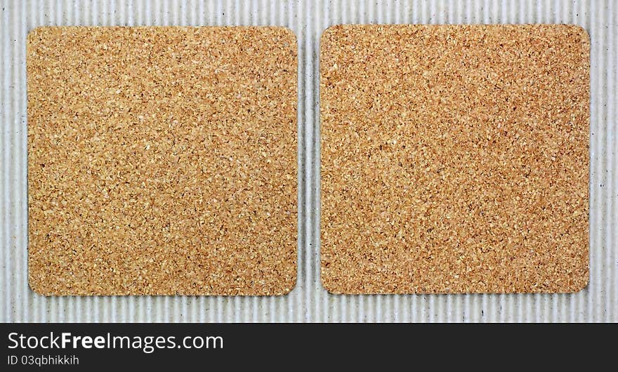 Two blank corkboards on corrugated paper