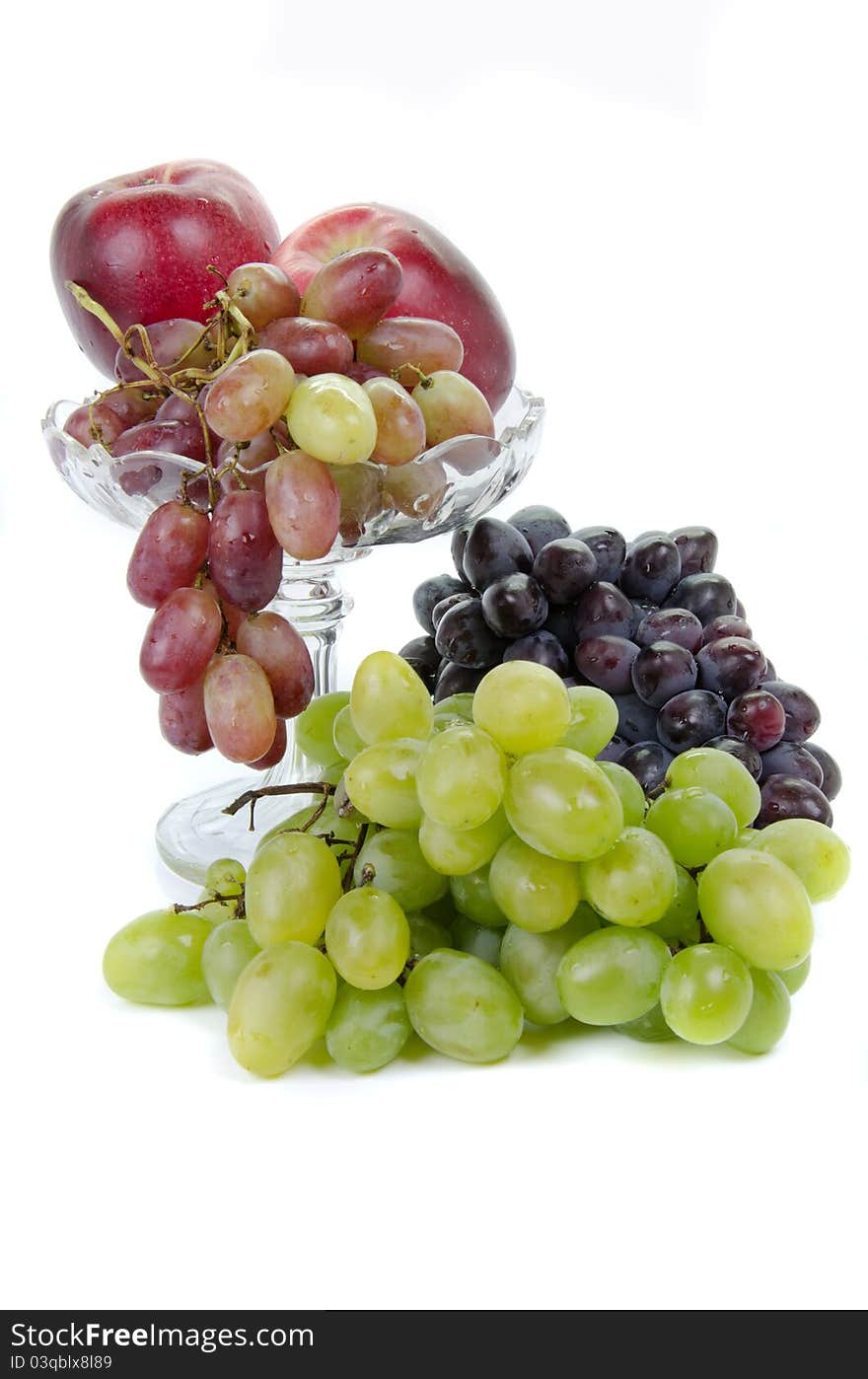 Fruits in glass vase on white background