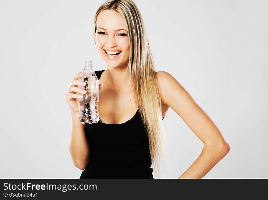 Cheerful beautiful woman with a bottle of fresh water. Cheerful beautiful woman with a bottle of fresh water