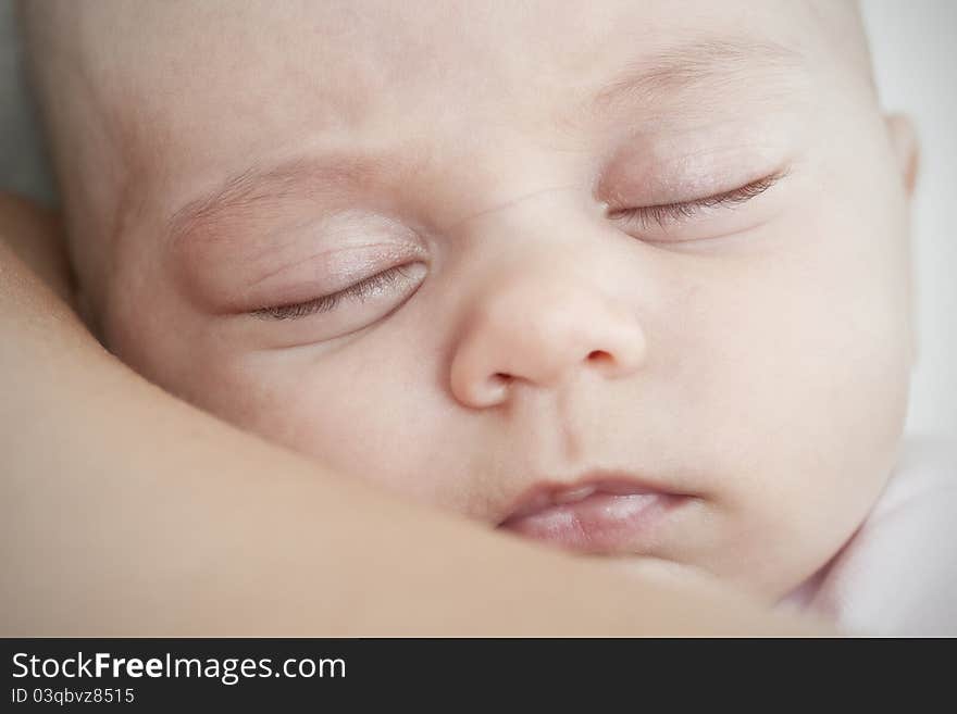 Newborn sleeping on the mother shoulder