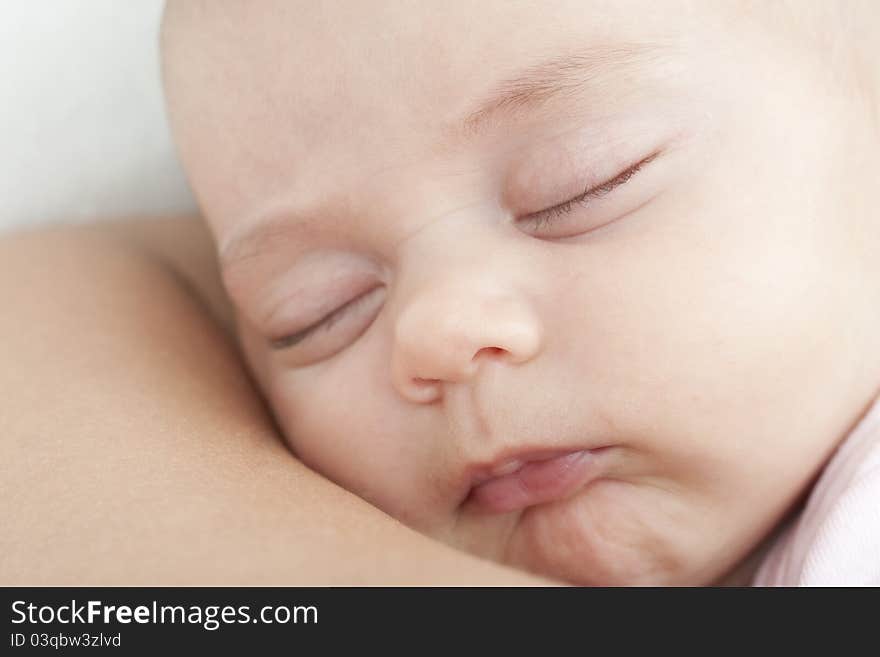 Newborn sleeping on the mother shoulder